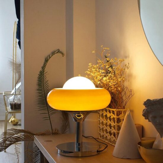 Pomarańczowa lampa stołowa Guzzini eklektyczna, zjawiskowa i elegancka. Do sypialni, do salonu, do gabinetu.