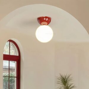 lampa sufitowa czerwona z mleczną kulą w jasnym holu